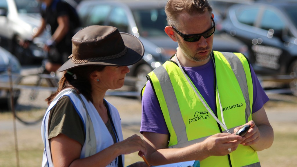 David looks and points at a stopwatch in his hand whilst Event Director Teresa Caswell looks on intently